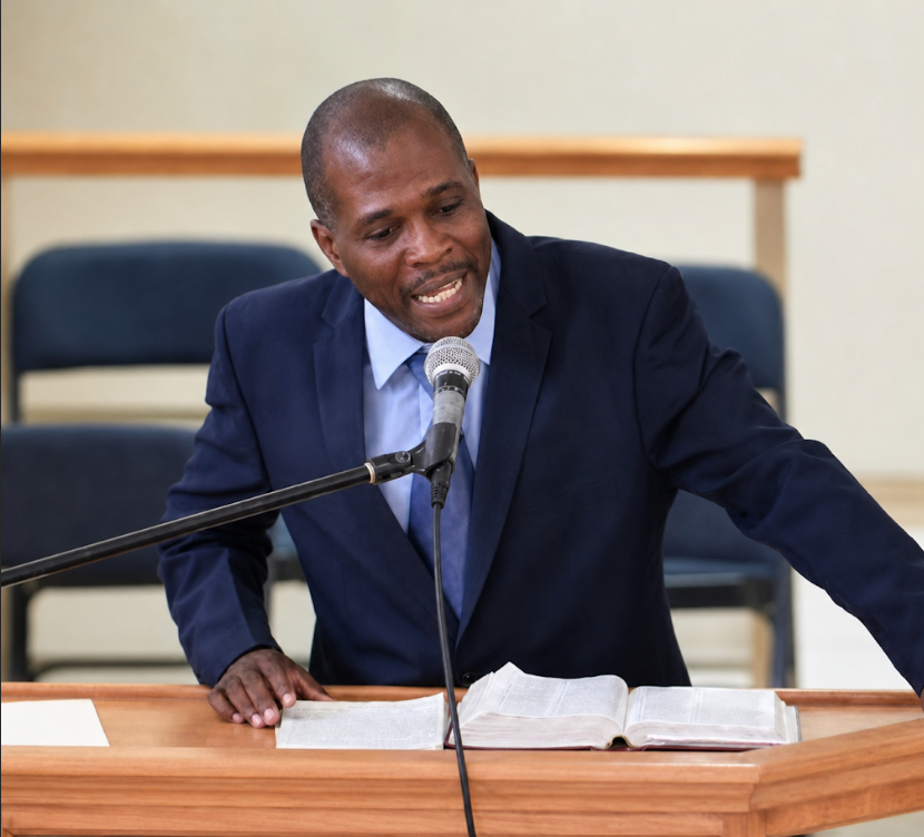 A pastor preaching from an open Bible at the pulpit
